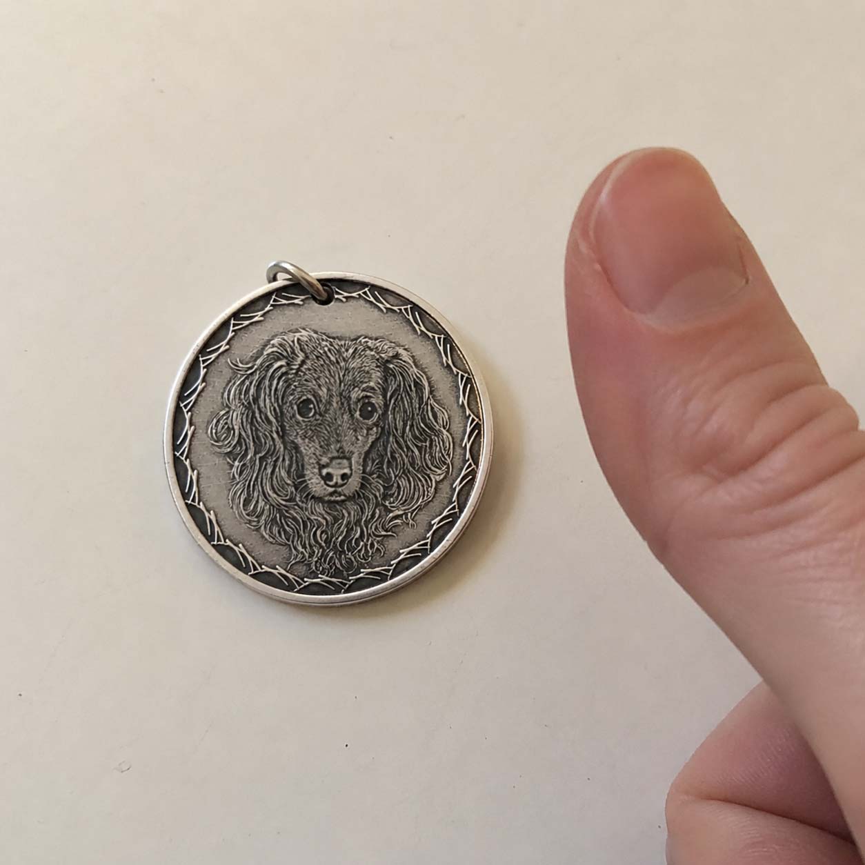 A hand-engraved silver pet coin kept close