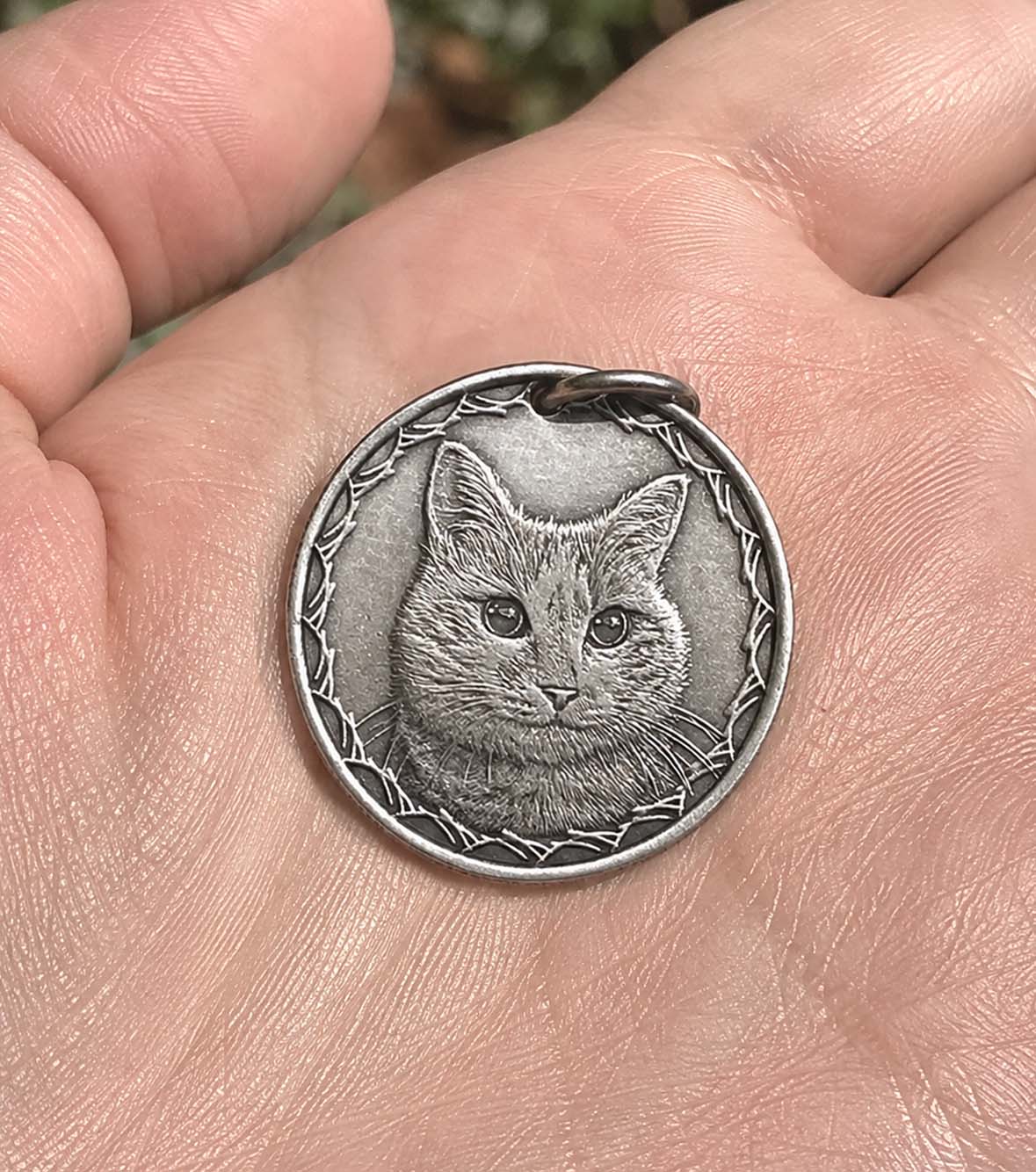 A hand-engraved silver pet coin kept close